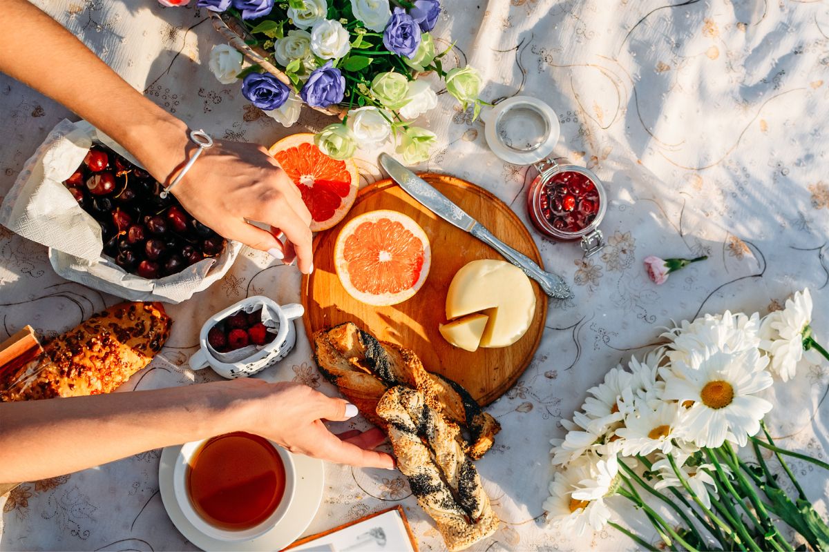 picnic spread with food, drinks and flowers