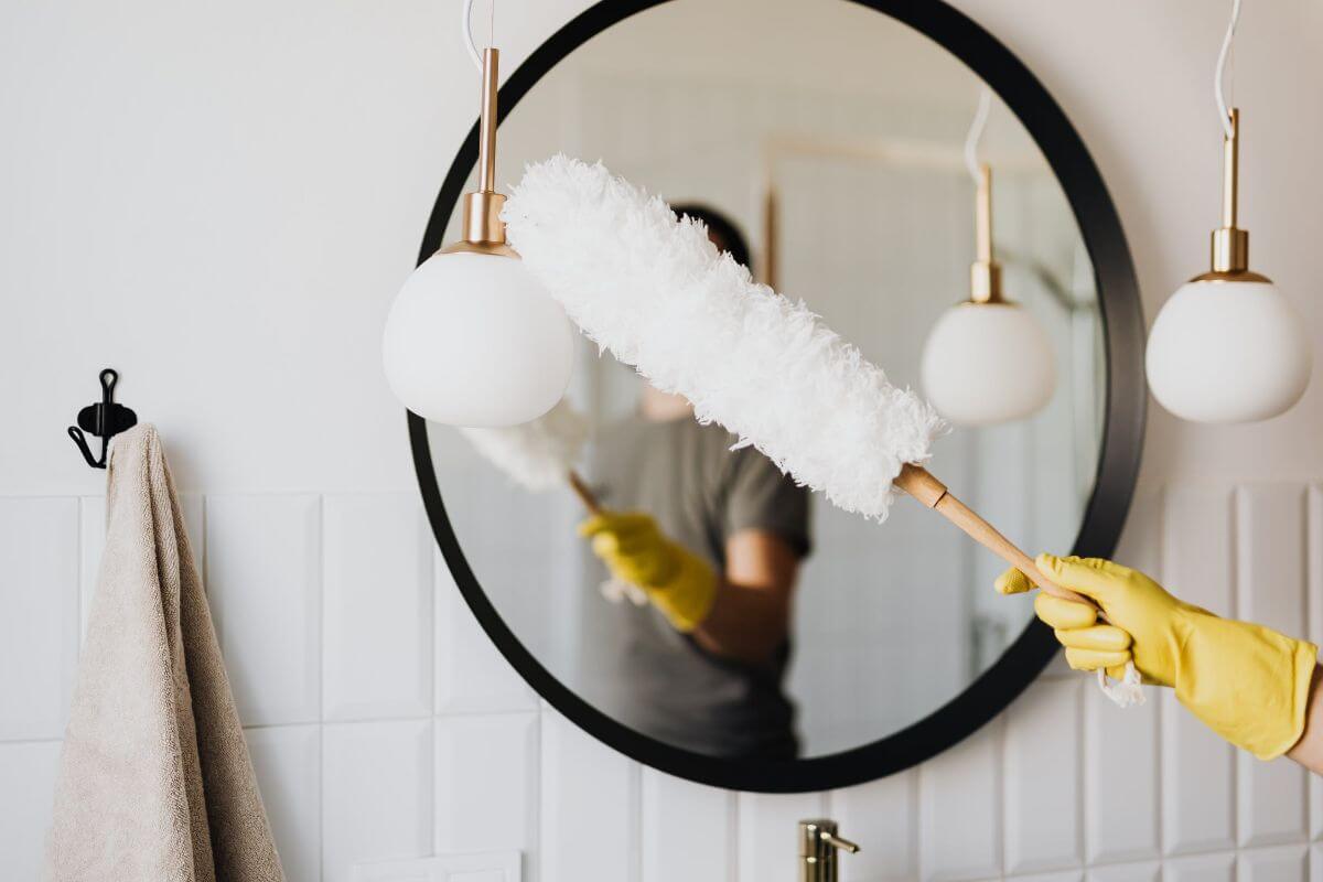 woman dusting lamp during housework