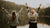 Two women with hand in the air in from of lake