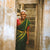 Smiling woman in doorway wearing green dress