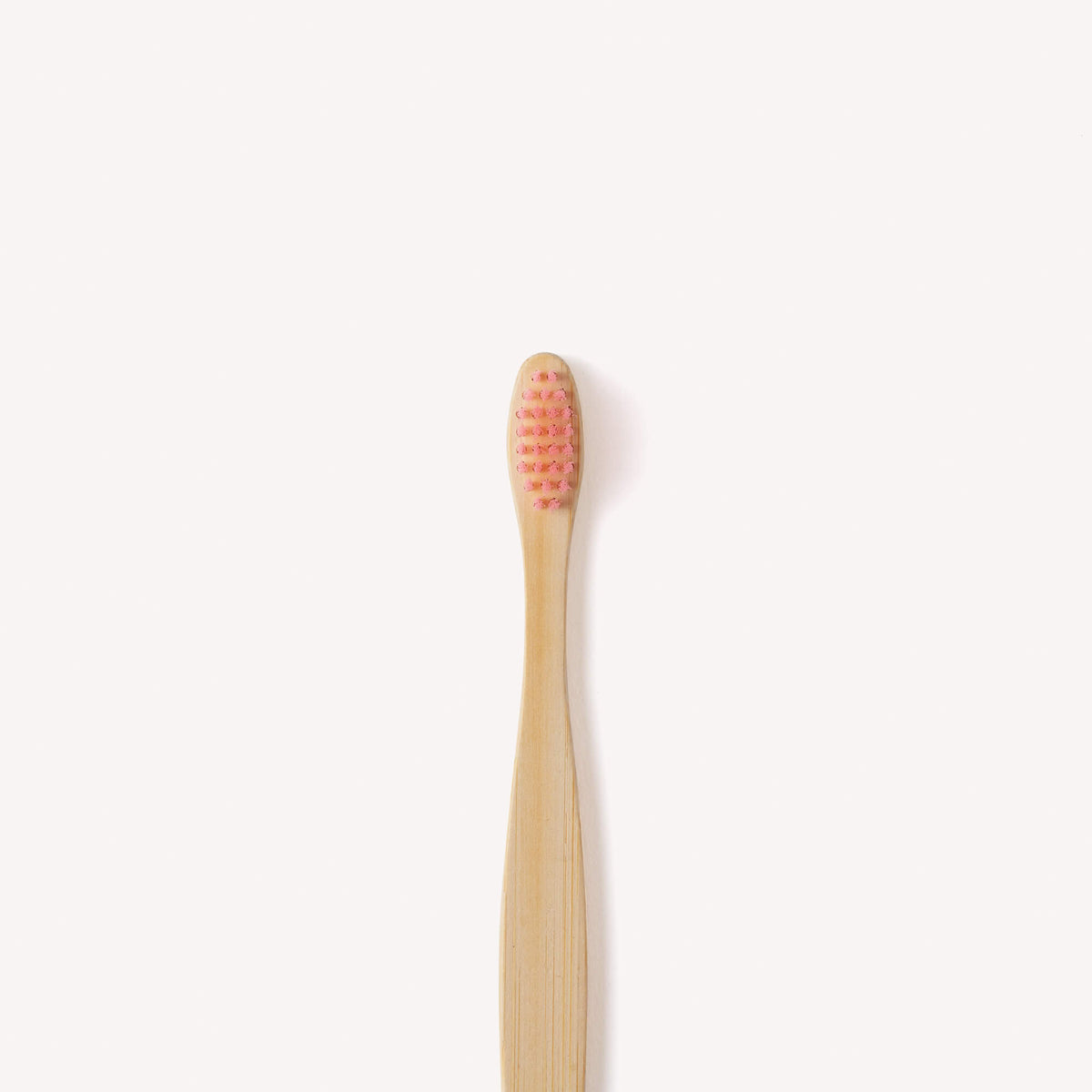 Close up view of our Children's Bamboo Toothbrush in pink.