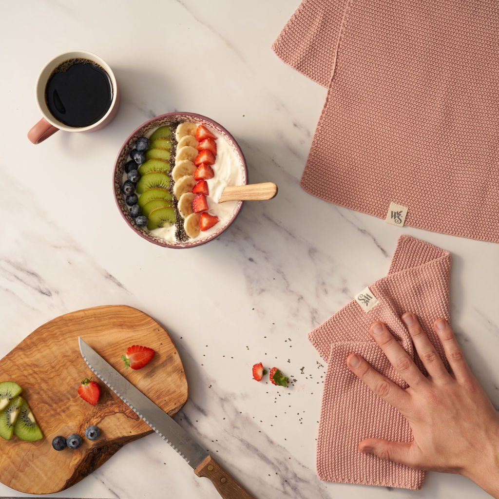 Person using the pink Organic Cotton Dishcloth.